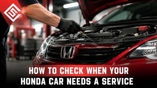 Mechanic checking under hood of red Honda car during maintenance inspection to identify service and engine issues.
